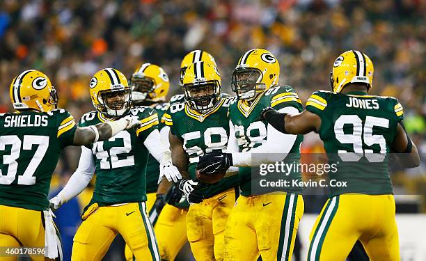 Letroy Guion of the Green Bay Packers celebrates a play with teammates in the first half against the Atlanta Falcons at Lambeau Field on December 8,...