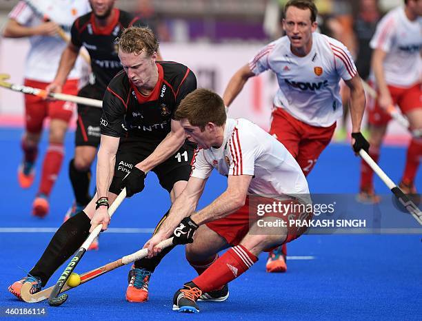 Belgium hockey player Amaury Keusters blocks England's Henry Weir during their Hero Hockey Champions Trophy 2014 match at Kalinga Stadium in...