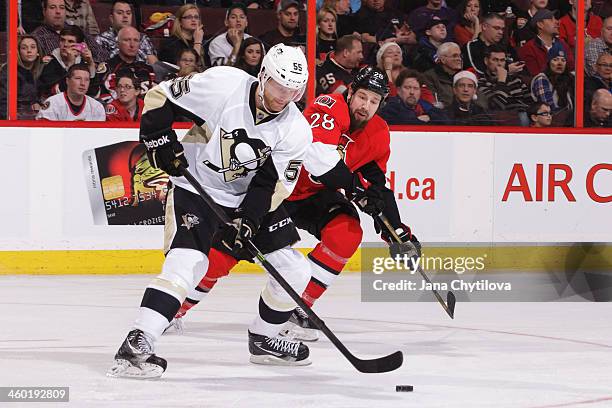 Philip Samuelsson of the Pittsburgh Penguins skates with the puck against Matt Kassian of the Ottawa Senators during an NHL game at Canadian Tire...