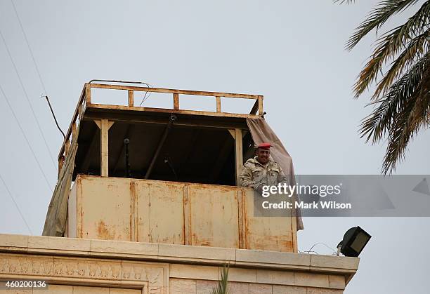 An Iraqi soldier stands guard on the roof of the Ministry of Defence during a visit from U.S. Secretary of Defense Chuck Hagel, December 9, 2014 in...