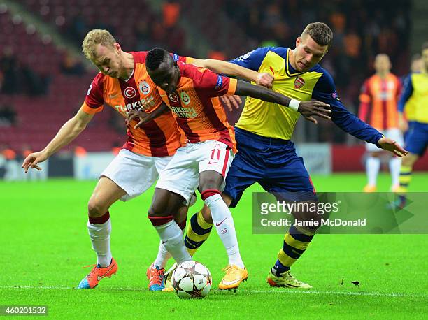 Lukas Podolski of Arsenal battles with Bruma and Semih Kaya of Galatasaray during the UEFA Champions League Group D match between Galatasaray AS and...