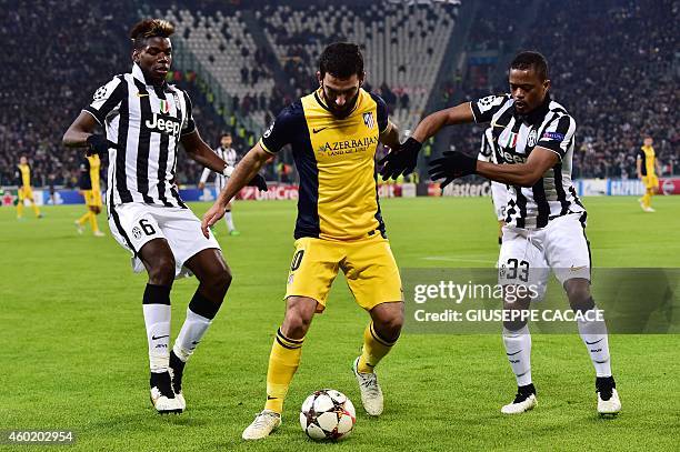 Juventus' defender from France Patrice Evra and Juventus' midfielder from France Paul Pogba fights for the ball with Atletico Madrid's Turkish...