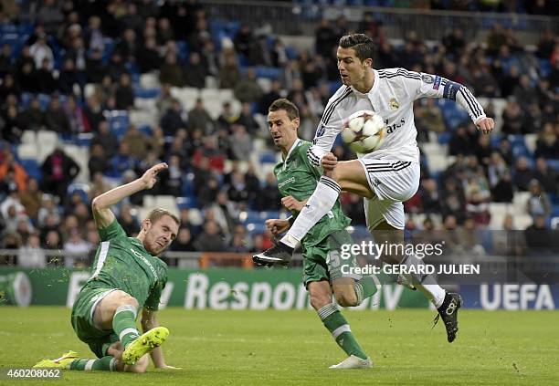 Real Madrid's Portuguese forward Cristiano Ronaldo kicks a ball past Ludogorets' Romanian defender Cosmin Moti during the UEFA Champions League Group...