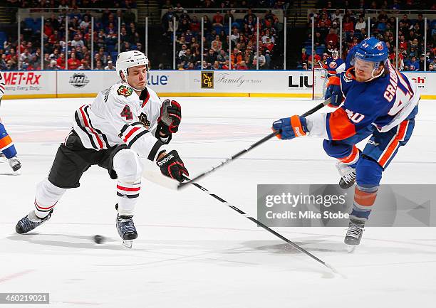 Niklas Hjalmarsson of the Chicago Blackhawks lunges to block a shot by Michael Grabner of the New York Islanders at Nassau Veterans Memorial Coliseum...