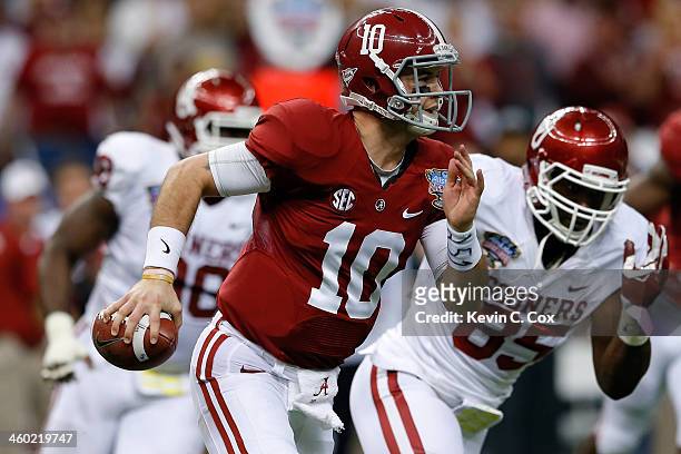 McCarron of the Alabama Crimson Tide runs with the ball past Geneo Grissom of the Oklahoma Sooners during the Allstate Sugar Bowl at the...