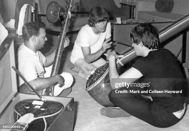 6th JULY: Paul McCartney and George Harrison centre, from The Beatles are given a sitar demonstration in Rikhi Ram's instrument shop in New Delhi,...