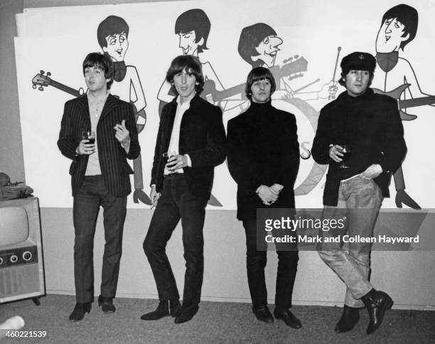 11th NOVEMBER: The Beatles pose in front of animated cartoons of themselves in London on 11th November 1964. From left to right: Paul McCartney,...
