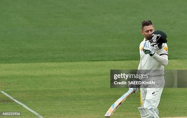 Australia's batsman Michael Clarke kisses his helmet as he celebrates his century on the second day of the first Test cricket match between Australia...