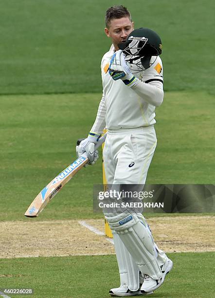 Australia's batsman Michael Clarke kisses his helmet as he celebrates his century on the second day of the first Test cricket match between Australia...