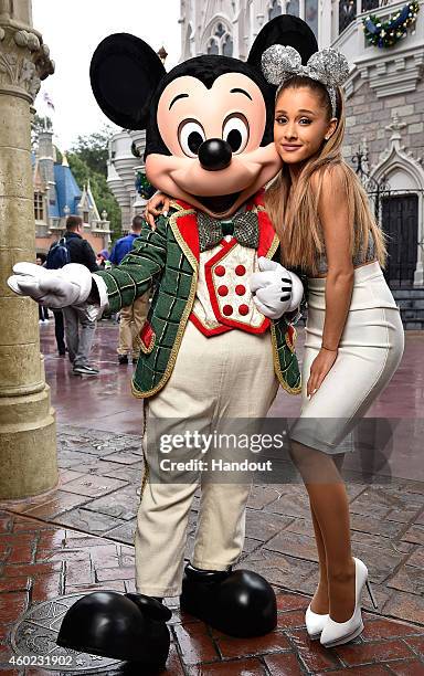 In this handout photo provided by Disney Parks, Ariana Grande poses with Mickey Mouse during the taping of the Disney Parks "Frozen Christmas...