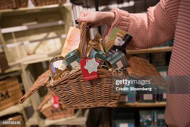 Shopper carries a festive hamper inside a pop-up store, operated by Fortnum & Mason Plc, during a seasonal Christmas event at Somerset House in...
