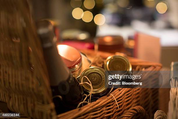 Branded jars and a bottle of Champagne sit in a food hamper displayed for sale inside a pop-up store, operated by Fortnum & Mason Plc, during a...