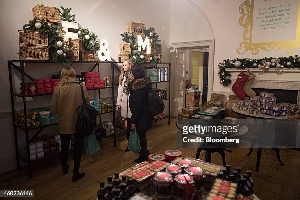 Shoppers browse specialty teas and festive foods displayed for sale inside a pop-up store, operated by Fortnum & Mason Plc, during a seasonal...