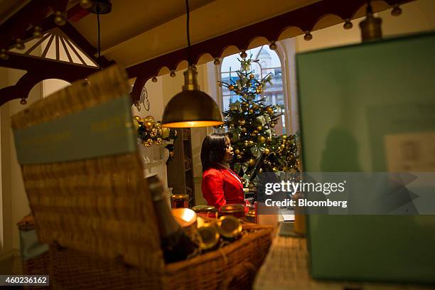 An employee stands at a checkout beside a decorated Christmas tree inside a pop-up store, operated by Fortnum & Mason Plc, during a seasonal...