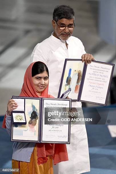 Nobel Peace Prize laureates Kailash Satyarthi and Malala Yousafzai hold their Nobel Prize at the the Nobel Peace Prize awarding ceremony at the City...