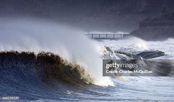 Professional surfer Alastair Mennie braves the conditions as he catches a wave on December 10, 2014 in Ballycastle, Northern Ireland. High winds and...