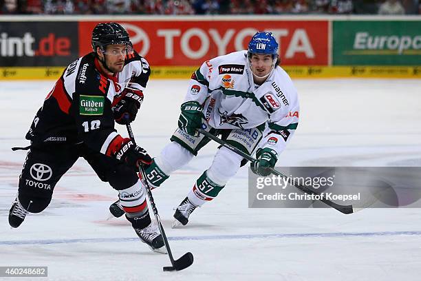Daniel Weiss of Augsburg challenges Jamie Johnson of Koelner Haie during the DEL Ice Hockey match between Koelner Haie and Augsburger Panther at...