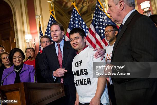 Sen. Richard Blumenthal puts his hand around Raul Esparza, United Farm Worker member, as Sen. Dick Durbin looks on, during a news conference to...