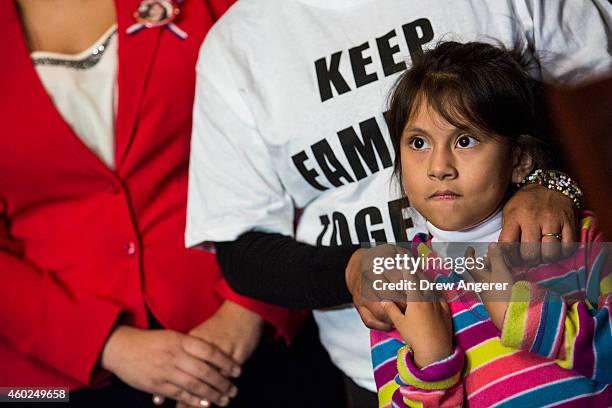 Heather Pina-Ledezma holds the hand of her mother Madai Ledezma from Mexico, now living in Maryland, during a news conference with Democratic...