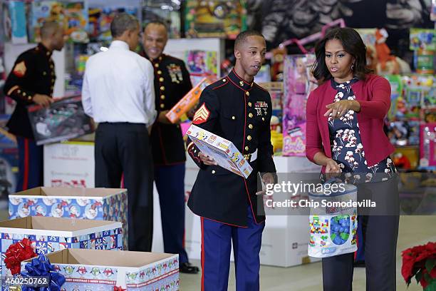 First lady Michelle Obama helps sort toys and gifts donated by Executive Office of the President staff to the Marine Corps Reserve Toys for Tots...