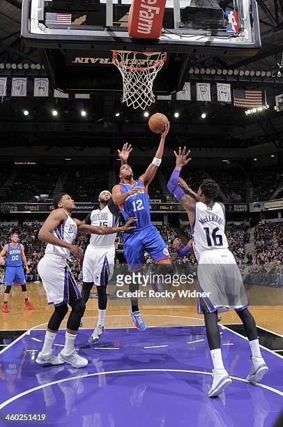 Evan Turner of the Philadelphia 76ers shoots the ball against Ben McLemore of the Sacramento Kings at Sleep Train Arena on January 2, 2014 in...