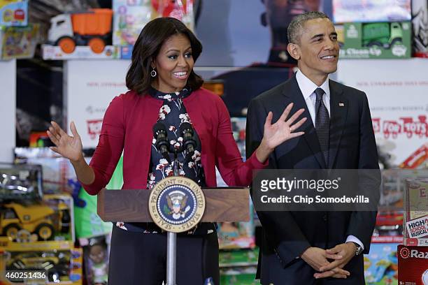 President Barack Obama listens as first lady Michelle Obama delivers remarks before sorting toys and gifts donated by Executive Office of the...