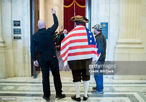 Man in a tri-corner hat wrapped in an American flag, who identified himself as James "Paul Revere" of Overpasses for America, stands outside the...