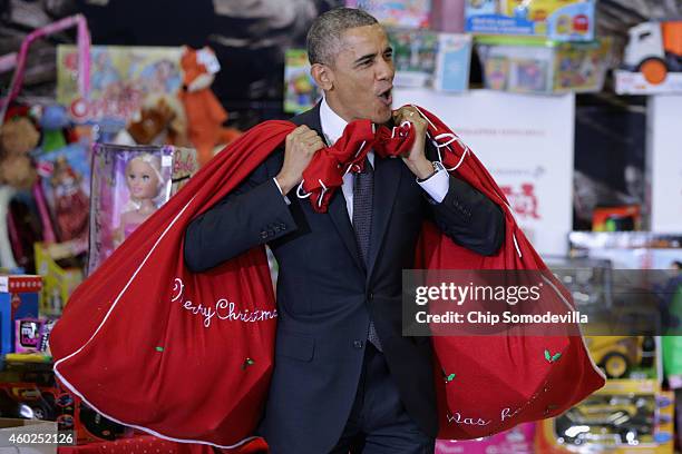 President Barack Obama, with bags slung over his shoulders, delivers toys and gifts donated by Executive Office of the President staff to the Marine...