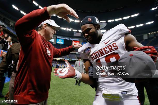 Head coach Bob Stoops celebrates with Eric Striker of the Oklahoma Sooners after defeating the Crimson Tide 45-31 to win the Allstate Sugar Bowl at...