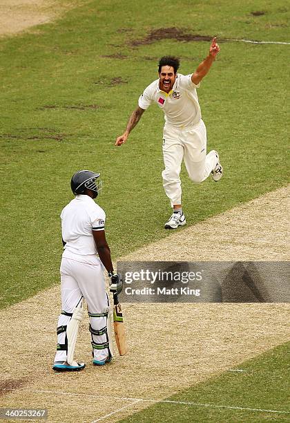 Mitchell Johnson of Australia celebrates taking the wicket of Michael Carberry of England during day one of the Fifth Ashes Test match between...