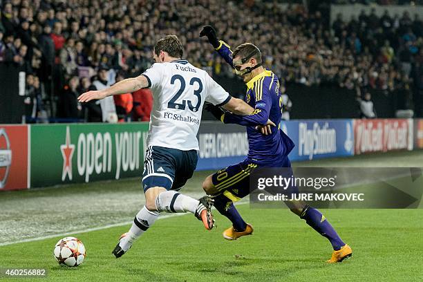 Schalke's Defender Christian Fuchs vies for the ball with Petar Stojanovic of NK Maribor during the UEFA Champions League Group G football match...