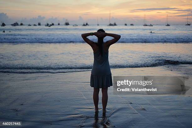 women w/ dress and arms in the neck. beach sunset - san juan del sur fotografías e imágenes de stock