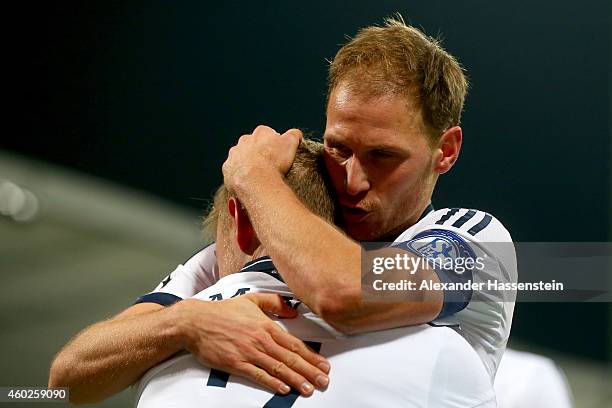 Max Meyer of Schalke celebrates scoring the opening goal with his team mate Benedikt Hoewedes during the UEFA Group G Champions League match between...