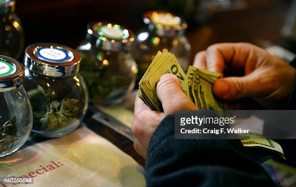 Tour members purchases marijuana at La Conte's Clone Bar & Dispensary during a marijuana tour hosted by My 420 Tours in Denver, CO on December 06,...