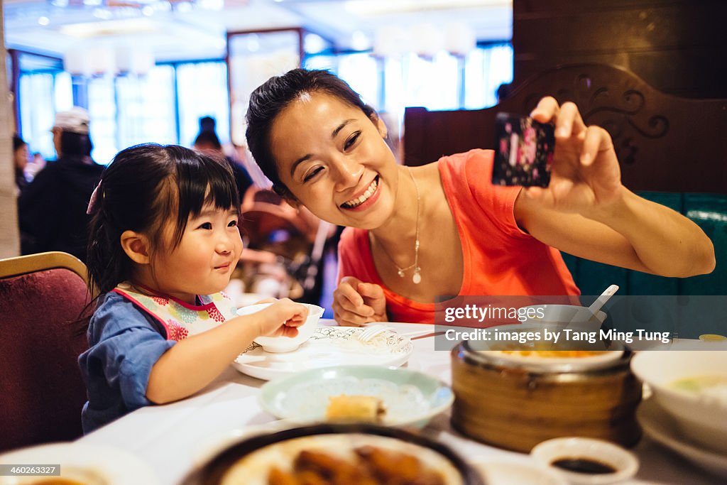 Mom & toddler taking selfie in Chinese restaurant