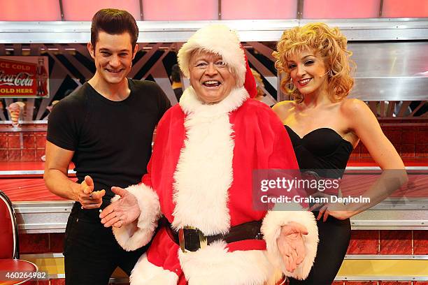 Bert Newton poses dressed as Santa Claus with Rob Mills as Danny and Gretel Scarlett as Sandy at the "Grease" musical at The Regent Theatre on...