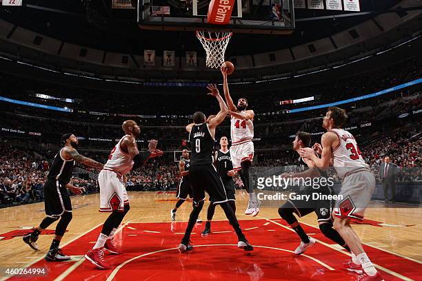 Nikola Mirotic of the Chicago Bulls goes to the basket against Jerome Jordan of the Brooklyn Nets on December 10, 2014 at the United Center in...