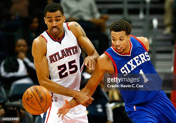 Thabo Sefolosha of the Atlanta Hawks and Michael Carter-Williams of the Philadelphia 76ers battle for a loose ball at Philips Arena on December 10,...