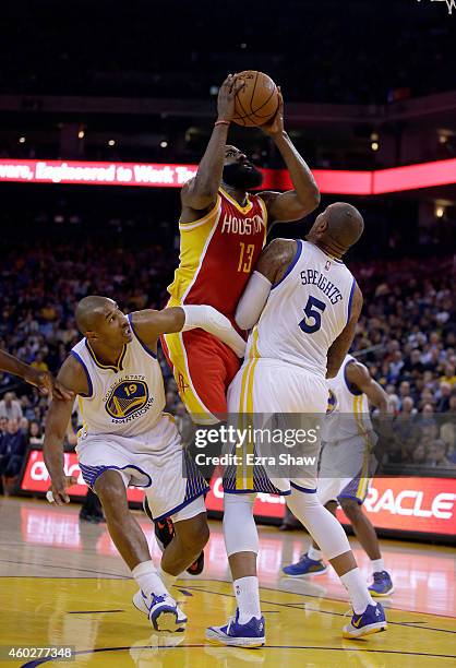 James Harden of the Houston Rockets shoots over Leandro Barbosa and Marreese Speights of the Golden State Warriors at ORACLE Arena on December 10,...