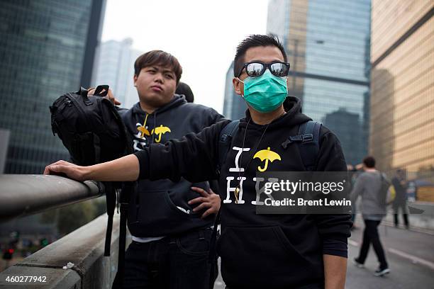 Pro-democracy protesters watch as court bailiffs, off camera, move toward a makeshift barricade outside Hong Kong's Government complex on December...