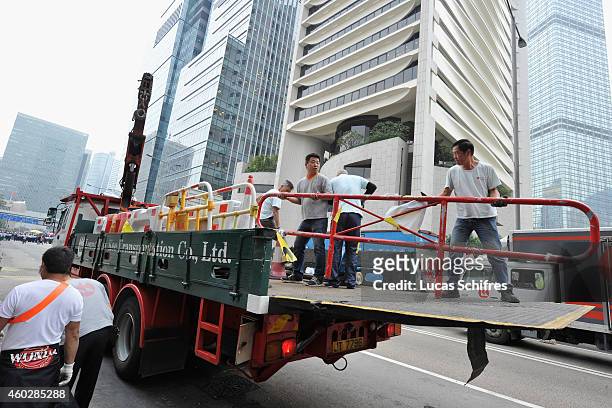 Workmen take down barricades put up by pro-democracy protesters under the supervision of bailiffs following a court injuction December 11, 2014 in...