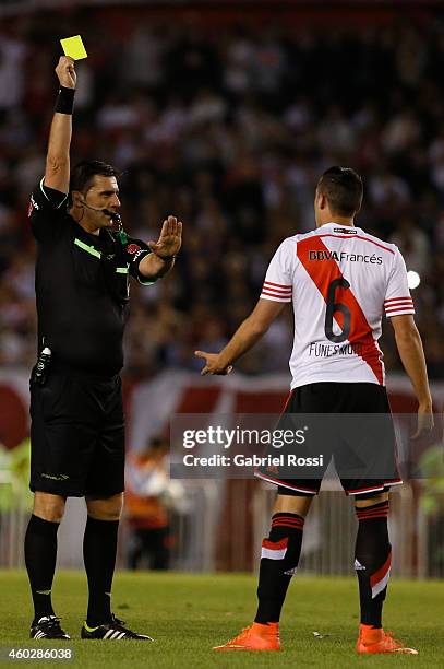 Referee Dario Ubriaco shows the yellow card to Ramiro Funes Mori of River Plate during a second leg final match between River Plate and Atletico...