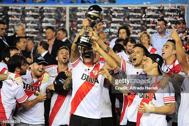 Teofilo Gutierrez and Leonel Vangioni of River Plate lift the trophy and celebrate with teammates after winning a second leg final match between...