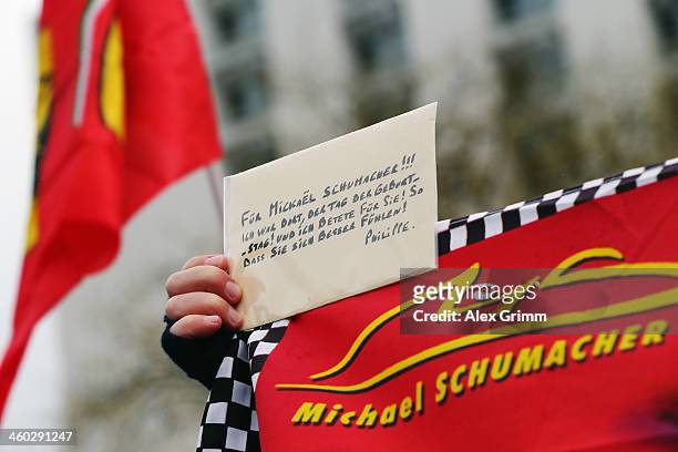 Fans gather outside the Grenoble University Hospital Centre to mark the 45th birthday of former German Formula One driver Michael Schumacher who is...