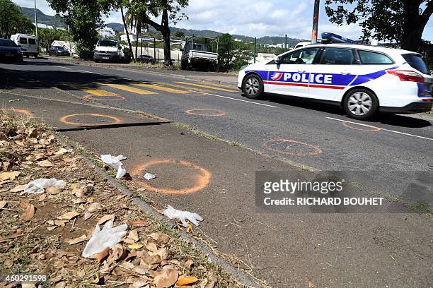 Police car drives in the street where five pedestrian students have been killed after being hit by a car the day before, on December 11, 2014 in...