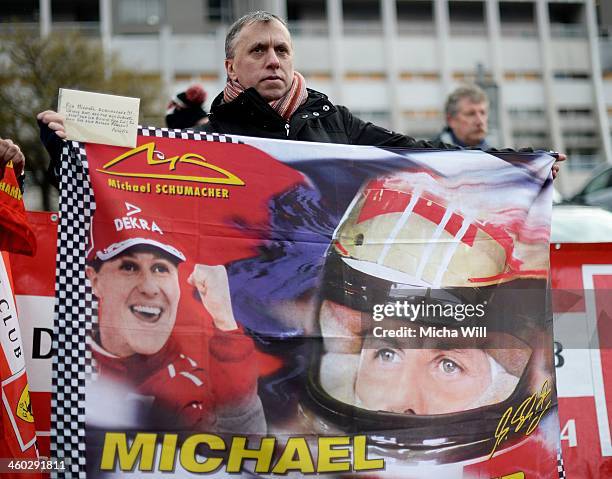 Man holds up a banner as fans and well-wishers hold a vigil for the former German Formula One driver Michael Schumacher at the Grenoble University...