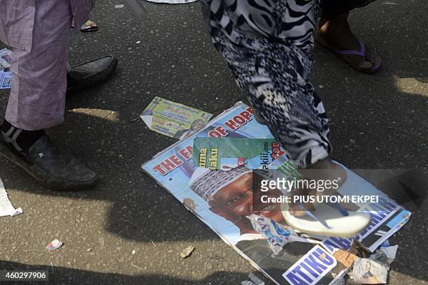 Passer-by steps on poster of the opposition All Progressives Congress presidential aspirant and former Vice-President Atiku Abubakar during the...
