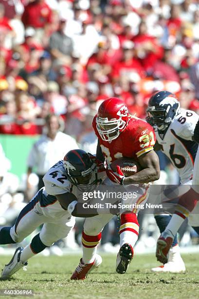 Priest Holmes of the Kansas City Chiefs runs through the tackle during a game against the Denver Broncos on October 5, 2003 at Arrowhead Stadium in...