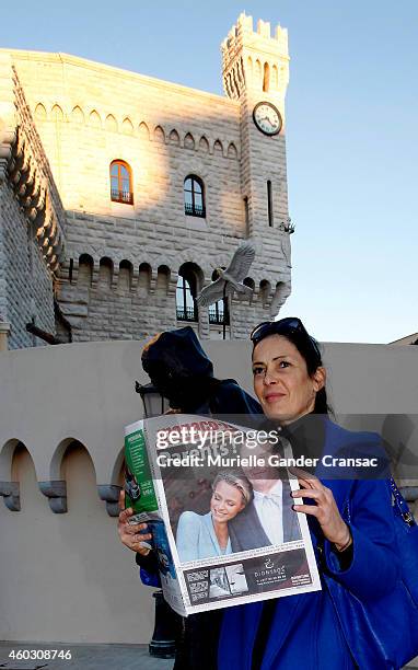 Woman reads an article about yesterday's birth of the royal twins Prince Jacques and Princess Gabriella outside the Monaco Palace on December 11,...