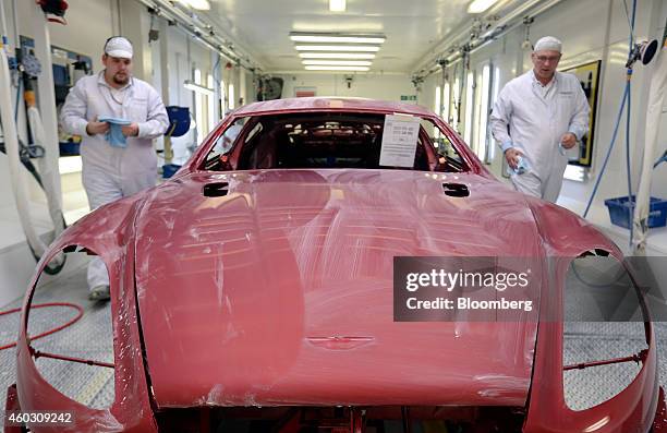 Employees prepare to polish the bodywork of an Aston Martin Rapide S automobile in the paintshop at Aston Martin Lagonda Ltd.'s manufacturing and...